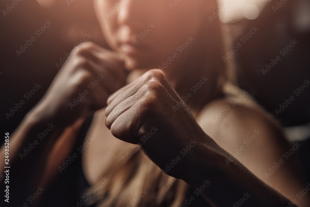 Young female boxer preparing to punch bag. concept of will win, power of spirit - obrazy, fototapety, plakaty 