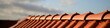 Dächer vom Dachdecker mit rotem Dachziegel Dachfirst. Dachpfannen auf Stadt Haus Neubau mit textfreiem Abendrot Himmel im Hintergrund.