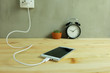 © damrong - Plug in power outlet Adapter cord charger of mobile phone on wooden floor