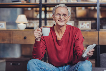 Wall Mural - Emotional pensioner drinking coffee while dealing with bills