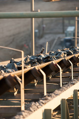 Sticker - Shallow depth of field image of ore on a conveyor belt heading up to a rock crusher at a mine in NSW, Australia