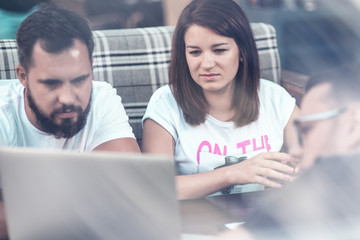 Businessmen discuss the deal and control it online, in a cafe on the street. A girl and two guys.