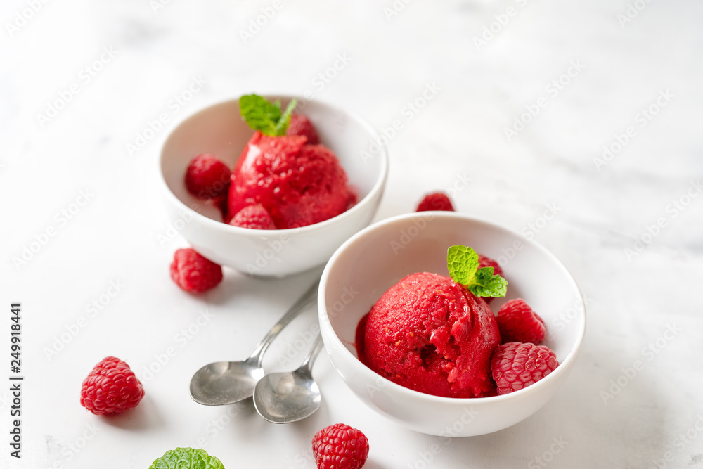 Raspberry sorbet in two cups on white table - obrazy, fototapety, plakaty 