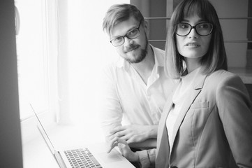 Young coworkers using laptop in office