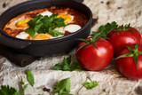Fototapeta Kuchnia - Pan of Fried Eggs with Tomatoes, Sweet Peppers and Coriander