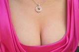 Female sensual cleavage with a pendant hanging on the neck