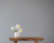 © Anna Cor - three white flowers in a little ceramic vase on an old wooden stool with lots of copy space
