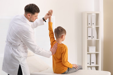 Wall Mural - Chiropractor examining child with back pain in clinic