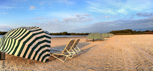 Beach Umbrella Cabanas Over Folding Chairs Along The White Sand Of