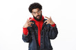 Celebrity posing paparazzi. Self-satisfied cool and arrogant african american bearded male rapper with afro hairstyle showing v signs or yo gesture as posing stylish and confident over gray wall