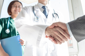 Wall Mural - Doctor and business people shaking hands