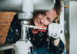 © Rawpixel.com - Woman fixing a kitchen sink