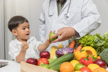 Wall Mural - Healthy and nutrition concept. Kid learning about nutrition with doctor to choose eating fresh fruits and vegetables.