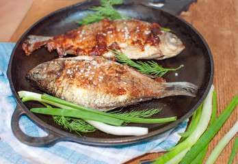 Fried carp fish on a griddle