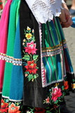 Kobieta (dolna część ciała) ubrana w tradycyjny strój ludowy z regionu Łowicza, polska, pasiasta kolorowa spódnica haftowana w kwieciste wzory