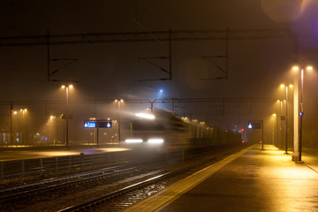 Wall Mural - Train in motion on the station at night, long exposure photo.