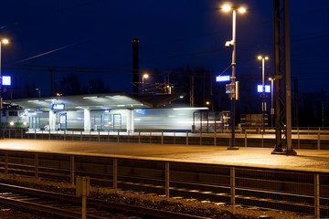 Wall Mural - Train in motion on the station at night, long exposure photo.