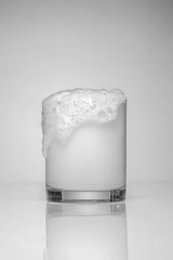 Soda large glass. overflowing glass of soda with bubbles.