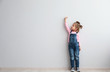 © Pixel-Shot - Portrait of cute little girl near light wall