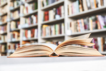 Canvas Print - Open book on table in library