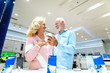 © Dusan Petkovic - Caucasian old couple discussing about the price for smart phone they want to buy. Tech store interior.