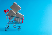Shopping Cart And Box On Blue Background, Business And Shopping Concept. Selective Focus