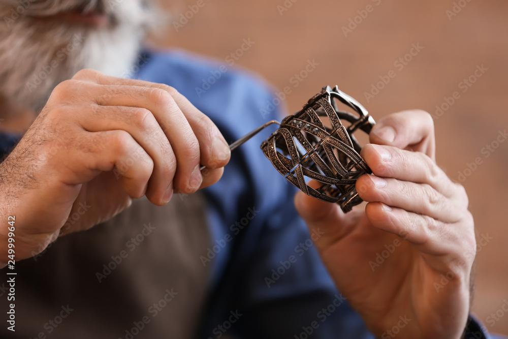 Jeweller making beautiful bracelet in workshop, closeup