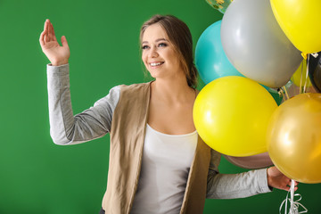 Wall Mural - Beautiful young woman with balloons on color background