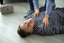 Woman Providing First Aid To Her Unconscious Husband At Home