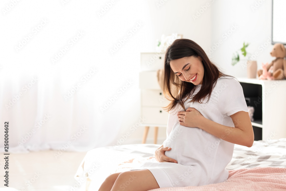 Beautiful pregnant woman in bedroom