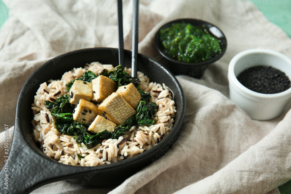 Tasty rice with tofu cheese in bowl on table