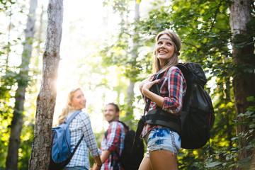 Wall Mural - beautiful woman and friends hiking in forest