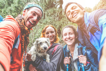 Wall Mural - Happy trekkers people taking selfie for social network story with their dog - Main focus on men faces