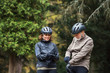 © Halfpoint - A senior couple with bicycle helmet standing outdoors on a road in park in autumn.