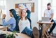 © Halfpoint - Portrait of young relaxed businesswoman with colleagues in a office, feet on desk.