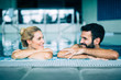 © NDABCREATIVITY - Happy attractive couple relaxing in swimming pool