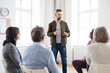 © Halfpoint - A man talking to other people during group therapy.