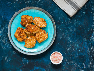 Homemade fried chicken cutlets, fillet nuggets in ceramic plate on dark blue background. Diet concept. Healthy food. Flat lay