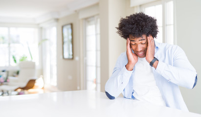 Canvas Print - African American man at home with hand on head for pain in head because stress. Suffering migraine.