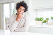 © Krakenimages.com - African American man at home looking confident at the camera with smile with crossed arms and hand raised on chin. Thinking positive.
