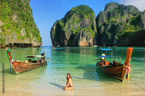 Fotomural Young woman sitting on the beach at Maya Bay on Phi Phi Leh Island, Krabi Provi