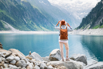 Wall Mural - Traveler look at the mountain lake. Travel and active life concept. Adventure and travel in the mountains region in the Austria. Travel - image