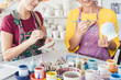 Frauen bemalen Geschirr mit Pinsel und Farben