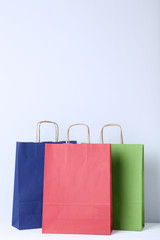 Wall Mural - Colorful paper shopping bags on grey background