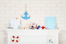 White Fireplace With Seashells And Photo Frames