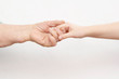 © leksann - the hands of an old man and a child holding each other on a white background. contrast. idea