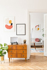 Wall Mural - Elegant and retro decor of living room with design commode, coffee table vinyl recorder, cacti and mock up posters frames on the white walls. Large space with brown wooden parquet and plants.