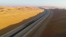 Aerial View Of A Long Train Crossing Vast Desert, U.A.E