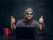 © Fxquadro - Satisfied hacker sits behind a laptop in a dark office