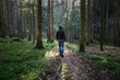 © robsonphoto - Man walking alone on mossy forest path.